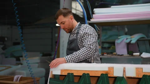 Worker Cutting Sofa Padding During Upholstery Process Stock Footage 305610739