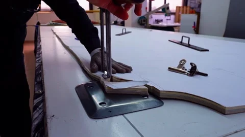 Worker Cutting Stacked Fabric with Vertical Electric Cutter and Steel Safet.. Stock Footage 336407135