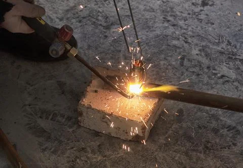 Worker cutting steel pipe using metal torch Stock Photos