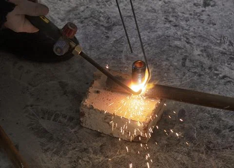 Worker cutting steel pipe using metal torch Stock Photos