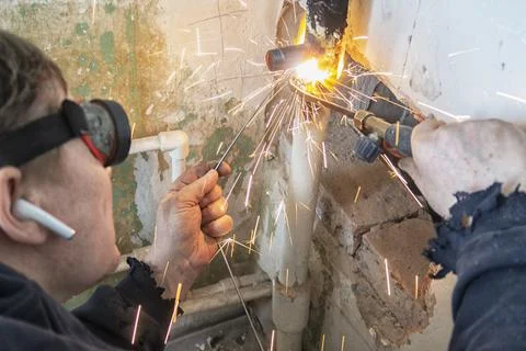 Worker cutting steel pipe using metal torch Stock Photos