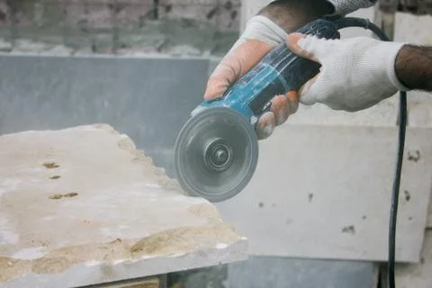 Worker cutting stone block by cutter machine. Stock Photos