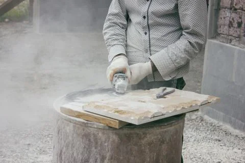 Worker cutting stone block by cutter machine. Stock Photos