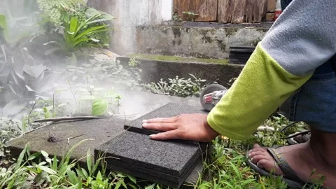 Worker cutting stone tile with angle grinder outdoors Stock Footage 324324499