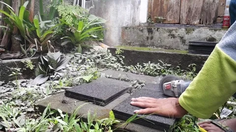 Worker cutting stone tile with angle grinder outdoors Stock Footage 324324587