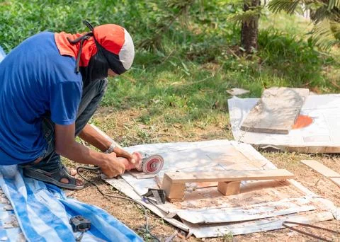 Worker cutting a tile with a grinder Stock Photos