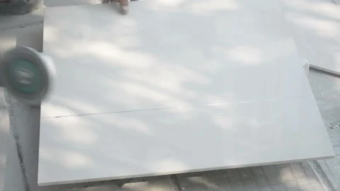 Worker cutting a tile using an angle grinder at construction site Vídeos de archivo 238909427