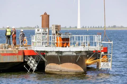 Worker with cutting torch at work by demolition offshore windturbine Stock Photos