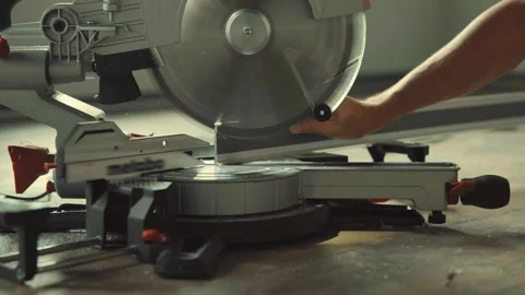 Worker cutting vinyl laminate flooring using electric miter saw Stock Footage 316389653