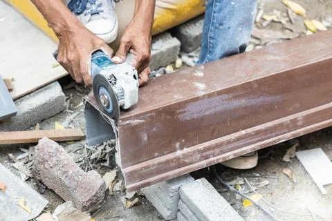 Worker cutting water gutter with disc cutter power tool Stock Photos