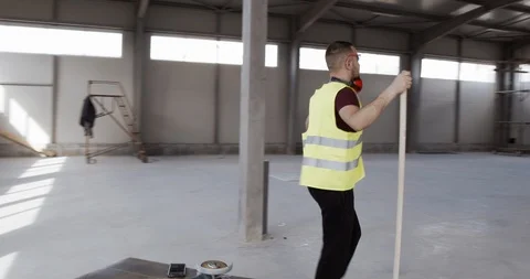 Worker dances with the sweeper while cleaning the deposit. Stock Footage 127034584
