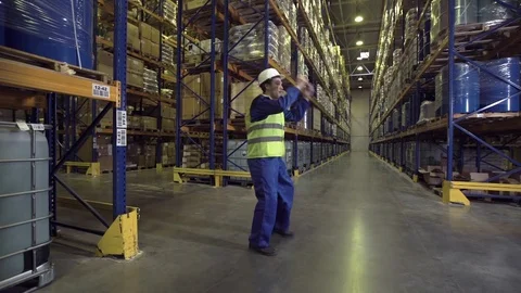 Worker dancing between racks in warehouse Stock Footage 75970019
