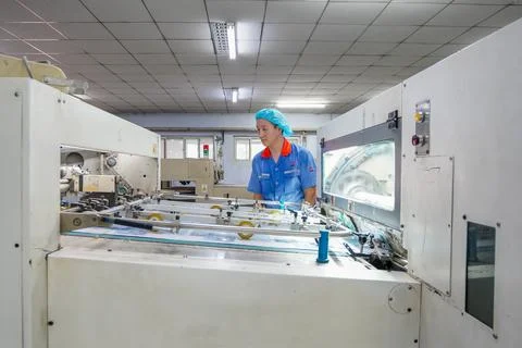 Worker Debugging Printing Conveying Equipment in Printing Workshop Stock Photos