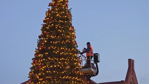 A worker decorates the Christmas tree on the city square Stock Footage 267179715