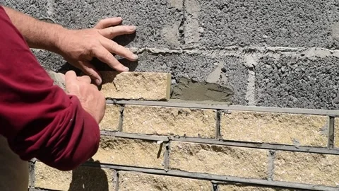 Worker decorates the facade of wall with decorative bricks. Process of cladding Video stock 153927626