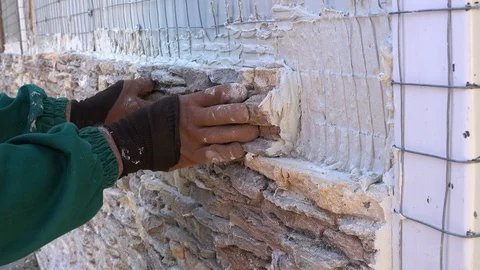 Worker decorating a wall with ornamental stone tiles pressing and fixing a tile Stock Footage 97289160