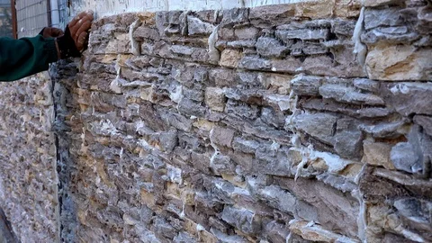 Worker decorating a wall with ornamental stone tiles pressing and fixing a tile Stock Footage 97290010
