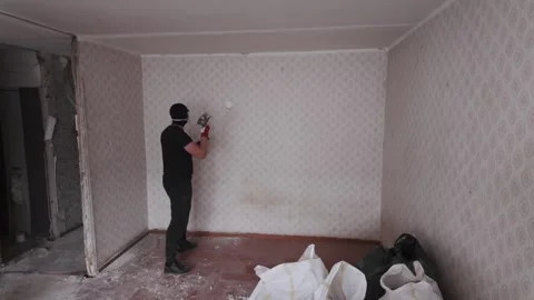 Worker Demolishing Old Wallpaper During Apartment Renovation Project Indoors Stock Footage 338431014