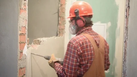 Worker with demolition hammer breaking interior wall Stock Footage 84192846