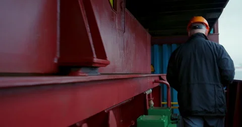 Worker descends narrow stairs under gray maritime light Vídeo Stock 320903098