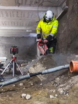 Worker diamond cutting granite using professional sawing equipment during b.. Stock Photos