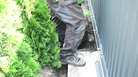 Worker Digs electric wires into the ground with a Shovel Stock Footage 258645754