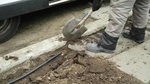 Worker Digs electric wires into the ground Stock Footage 268704828
