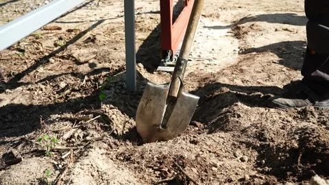 Worker Digs a trench with a shovel at a construction site Stock Footage 258645631