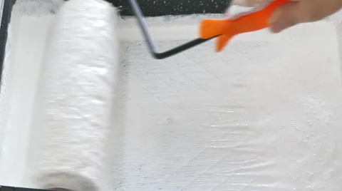 Worker dipping roller into paint tray Stock Footage 56353343