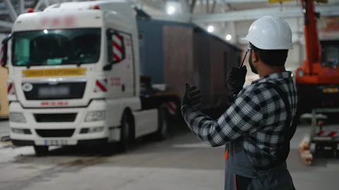Worker directing modular home loading onto transport truck Stock Footage 301824341