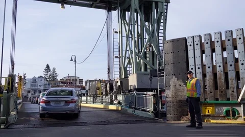 Worker directing vehicle traffic exiting the Washington State Ferry Stock Footage 121237895