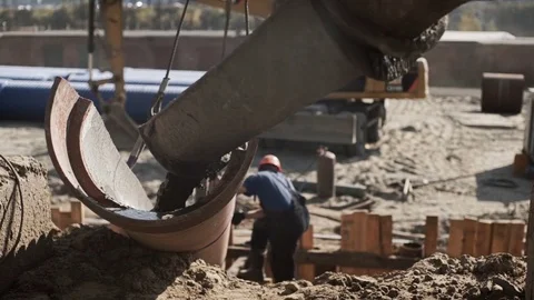 Worker directs the flow of cement on a trench at a construction site Stock Footage 71219389