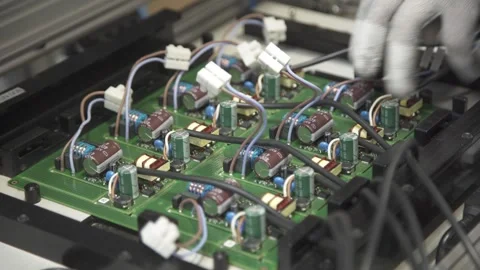 A worker disconnects cables from a pcb after diagnosing it in a special tester. Stock Footage 252644766