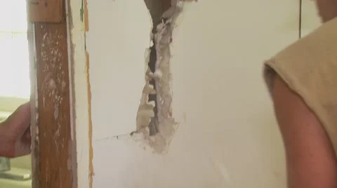 Worker dismantling wall with hammer Stock Footage 55570696