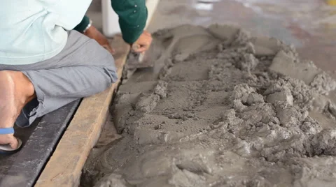 Worker distributes cement with trowel Stock Footage 53234256