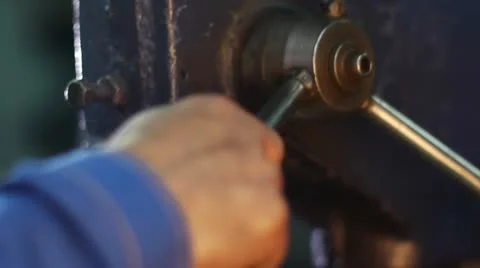 A worker does opening a drilling machine-tool in a metallic pipe at the plant Stockbeeldmateriaal 11339408