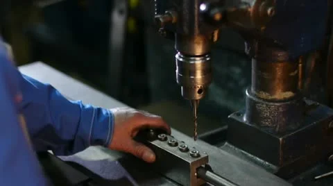 A worker does opening a drilling machine-tool in a metallic pipe at the plant Stockbeeldmateriaal 11339419