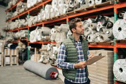 Worker doing an inventory check on a warehouse floor Stock Photos