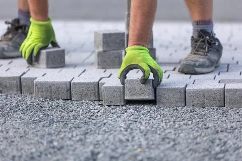 Worker doing new interlocking paving sidewalk made from concrete blocks Stock Photos