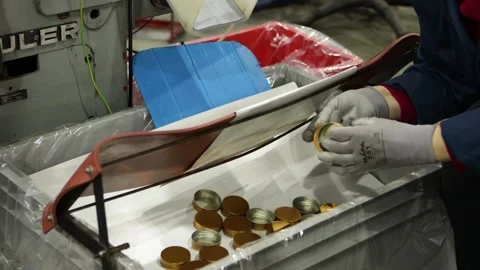 Worker doing quality control on caps piling up in a box in a factory Stock Footage 274737623