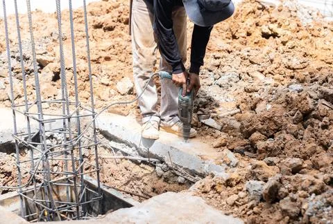Worker drill floor with electric drill to install supporting formwork . Foto stock