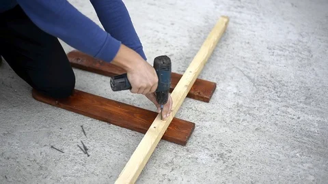 Worker drill twists the screwdriver screws in a wooden block Stock Footage 121961225