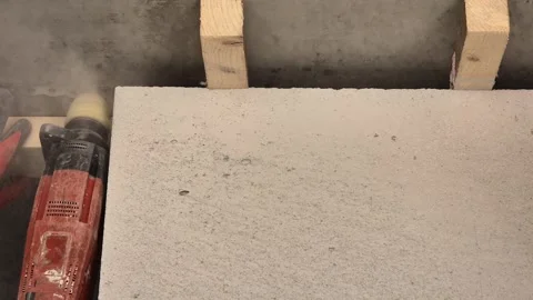 Worker drilling concrete ceiling to install steel strapping for interior wall Stock Footage 333588462