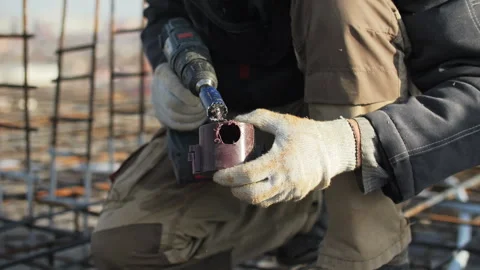 Worker drilling into an electrical junction box on a construction site Stock Footage 300337547