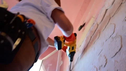 Worker drilling a hole in a bathroom wall during renovation Vidéo 346958799