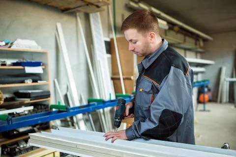 Worker with drilling mashine in workshop Stock Photos