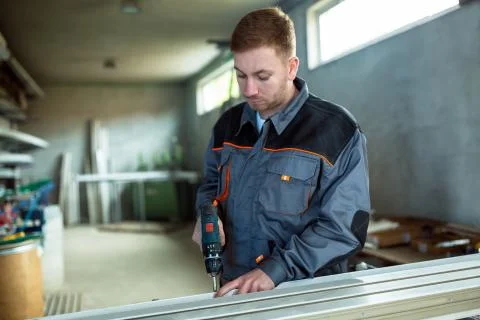 Worker with drilling mashine in workshop Stock Photos