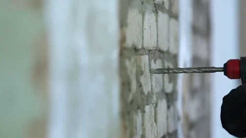 A worker drills a brick wall with a drill removed the slider Stock Footage 72558328
