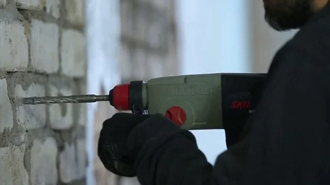 A worker drills a brick wall with a drill large Stock Footage 72558348