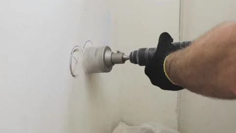 A worker drills a concrete wall with a diamond crown on a perforator  動画素材 147172845